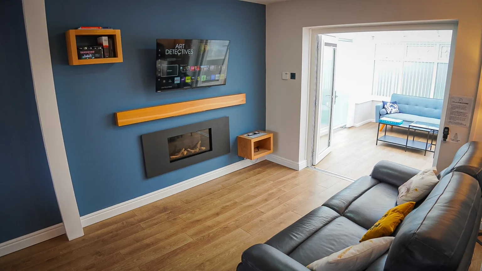 Comfortable living room with deep blue walls, sofas and a fireplace